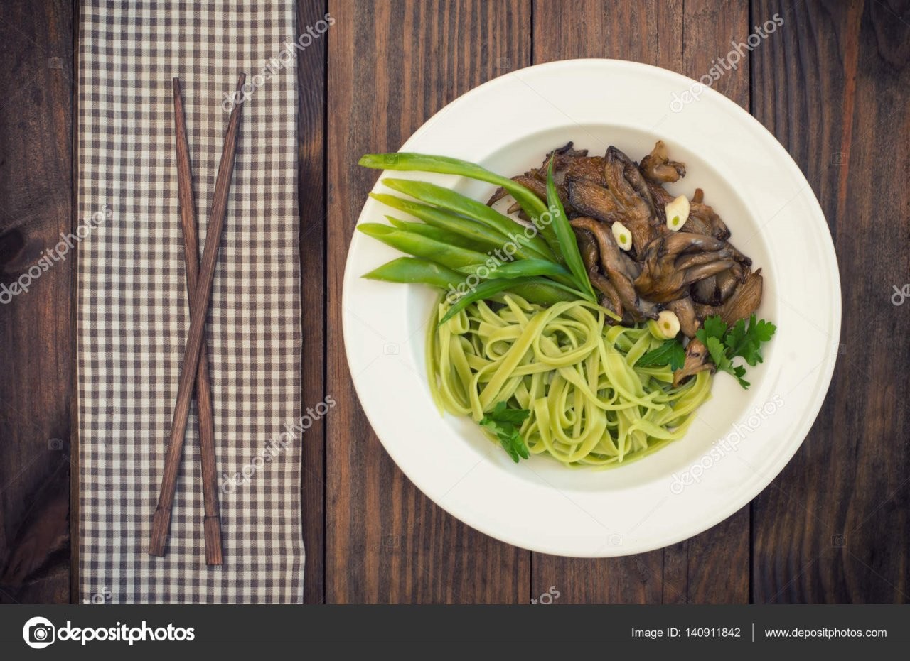 Teller Mit Spaghettiteig Mit Spinat Und Austernpilze Italienische von Italienische Kochrezepte Mit Bildern Photo