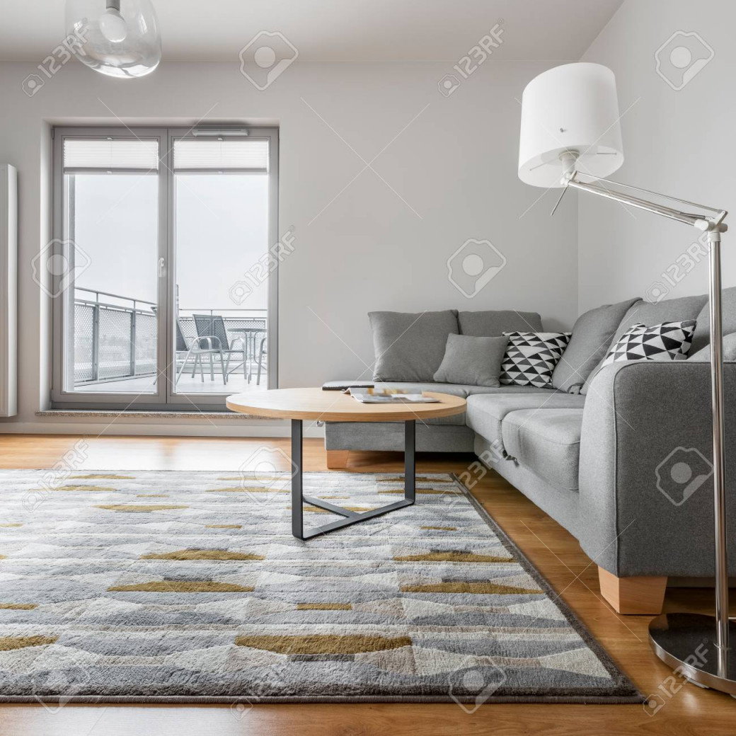 Graues Und Weißes Wohnzimmer Mit Sofa Lampe Teppich Runder Tisch Und  Balkon von Wohnzimmer Runder Teppich Bild